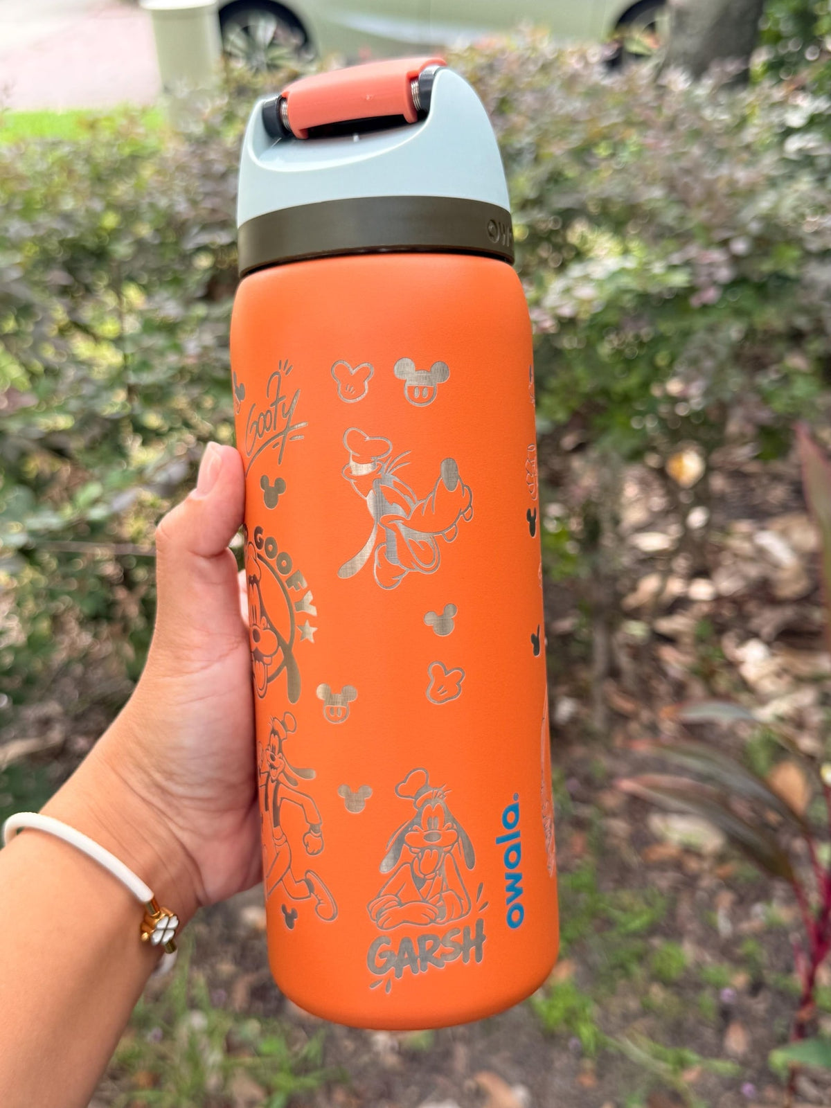 Side view of an orange Owala with engraved Goofy artwork