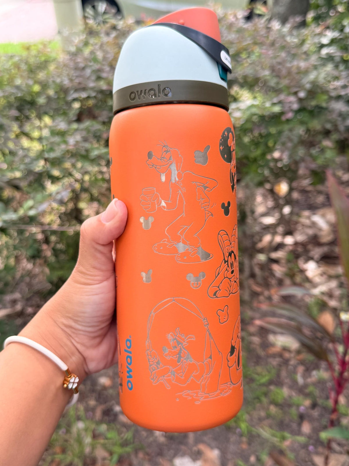 Back of an orange Owala FreeSip with more engraved Goofy details