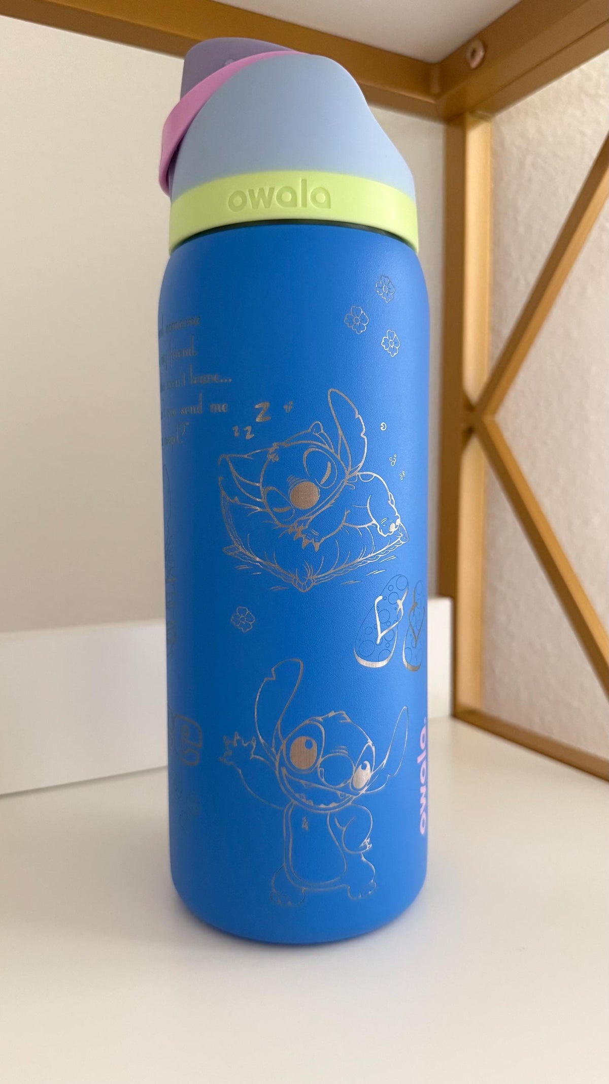 Blue engraved Owala FreeSip with Stitch artwork wrapping around the bottle