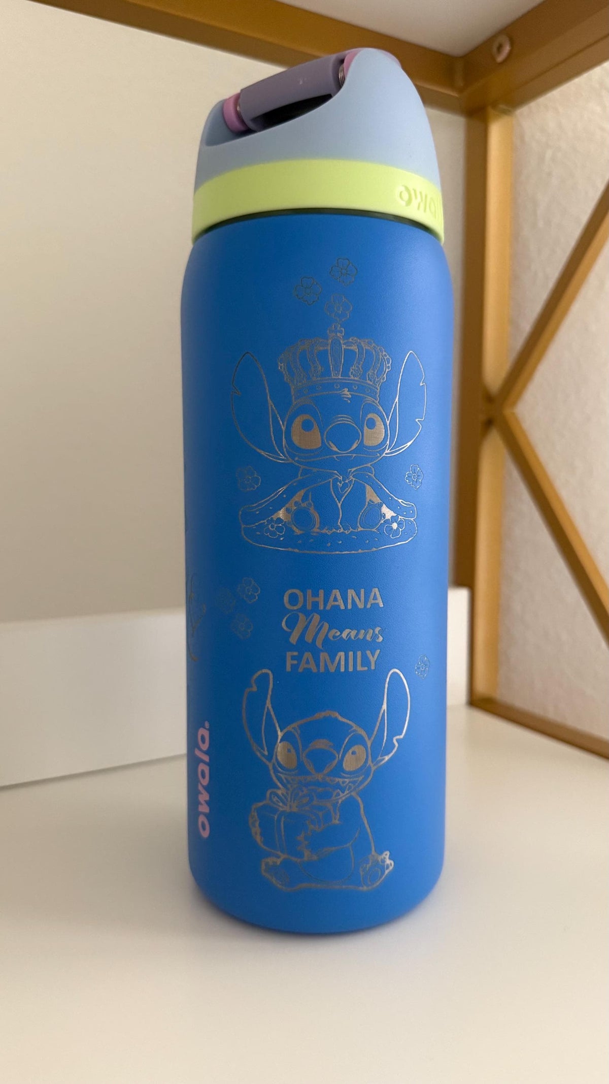 Close-up of the Stitch and Ohana engraving on a blue Owala FreeSip