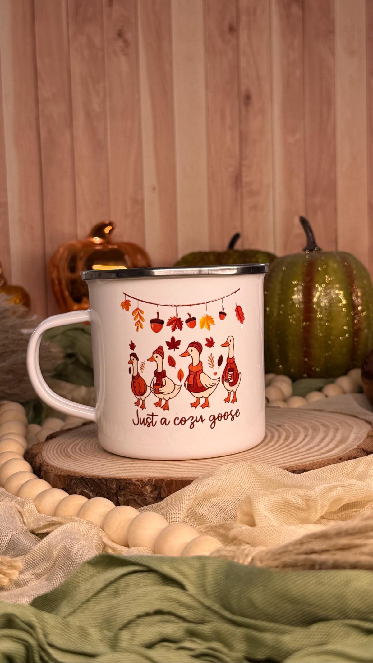 Fall goose enamel mug on a wood slice with pumpkins