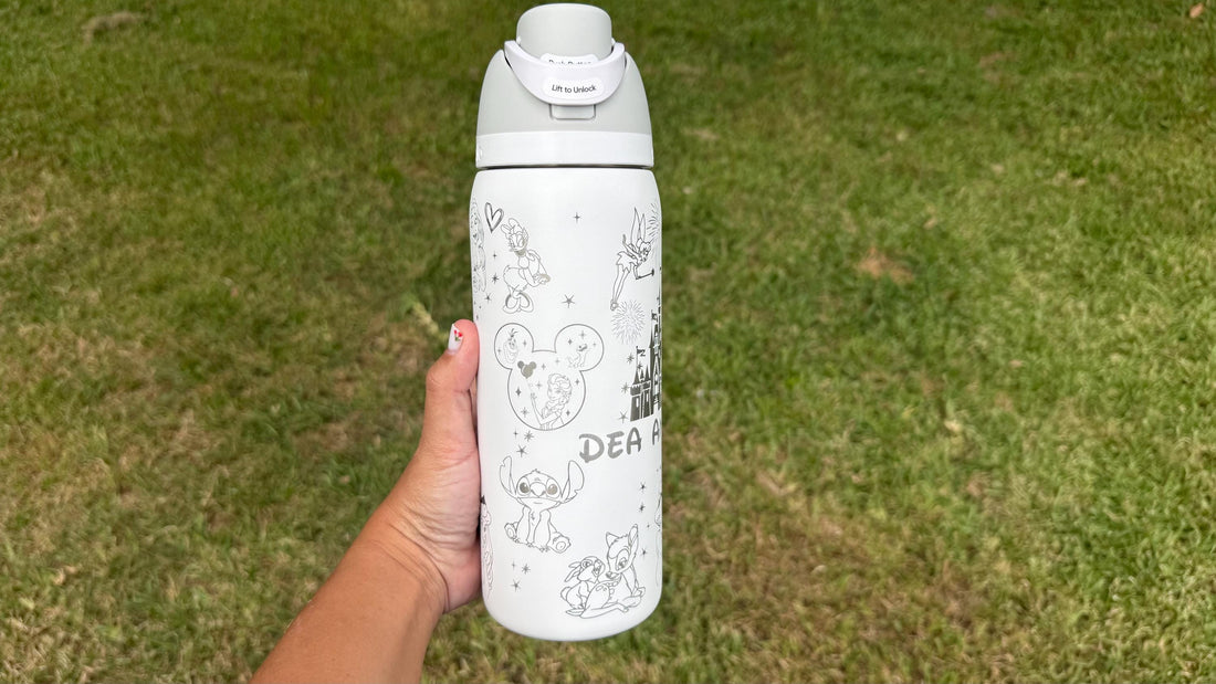 White Owala FreeSip laser engraved with a Disney-inspired castle, characters and the name Dea Anna