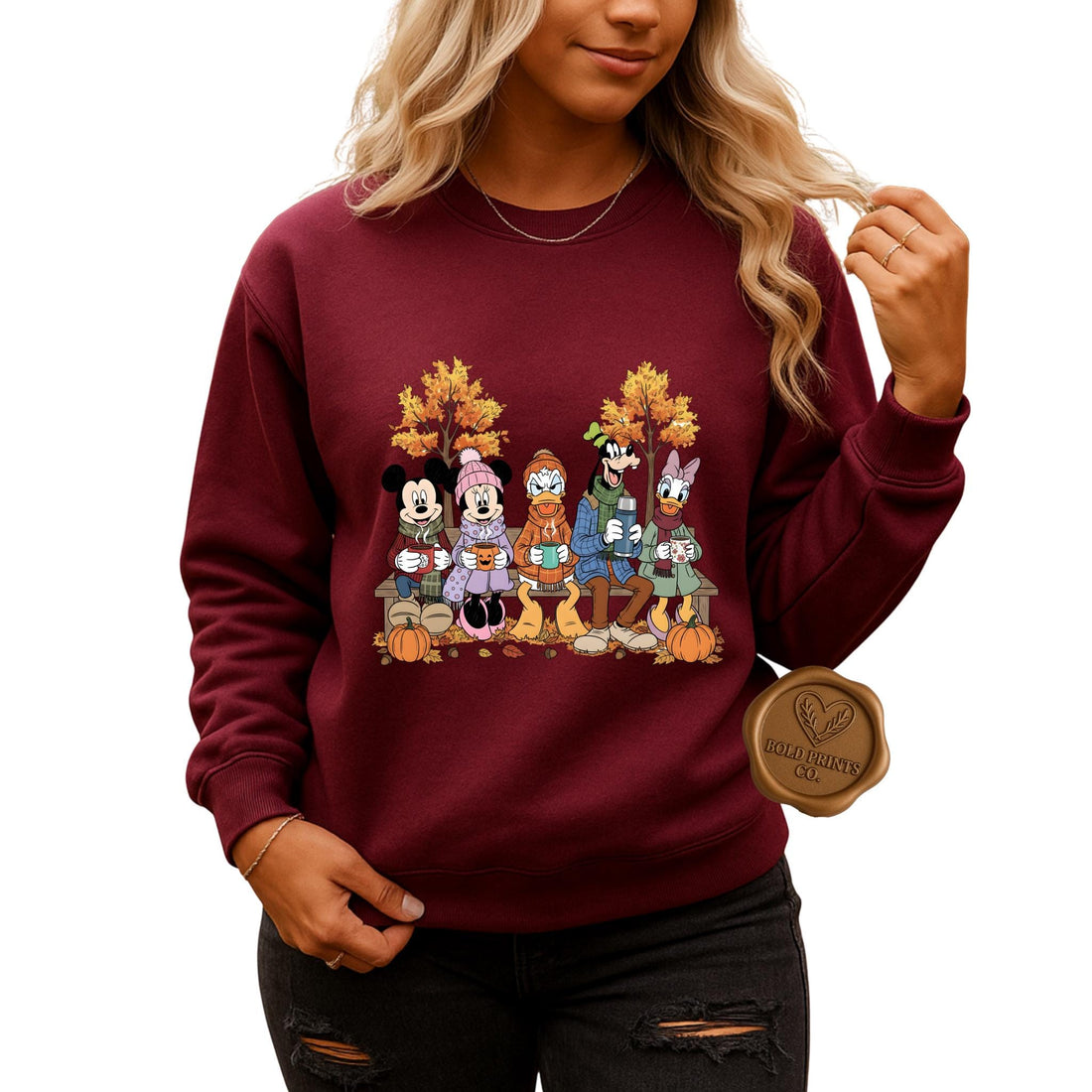 Woman wearing a maroon Mickey and Friends-inspired fall sweatshirt outdoors