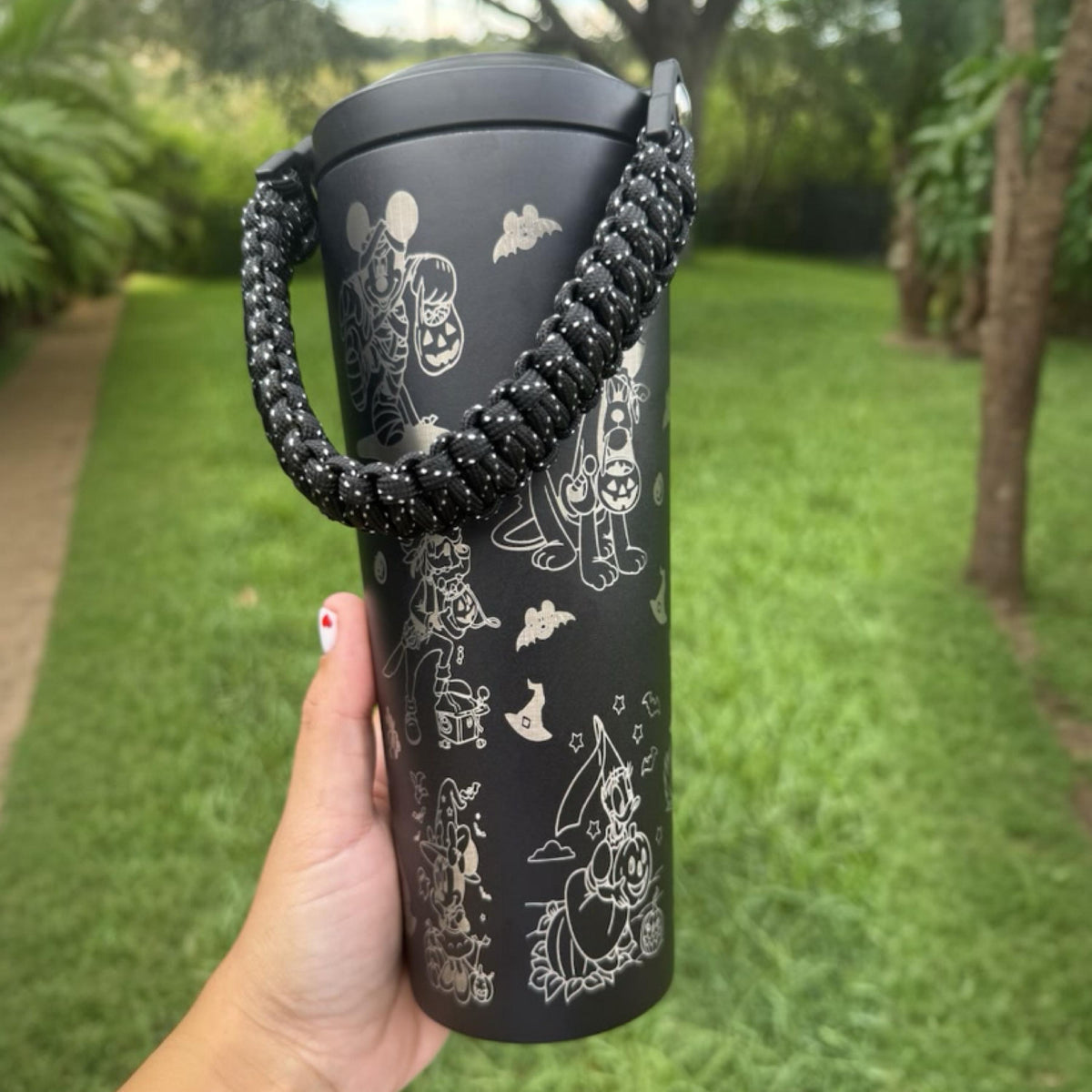 Black Halloween tumbler with carry strap held outdoors