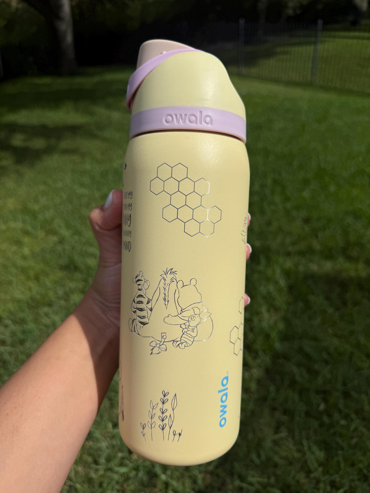 Honeycomb and Pooh engraving on a yellow Owala water bottle
