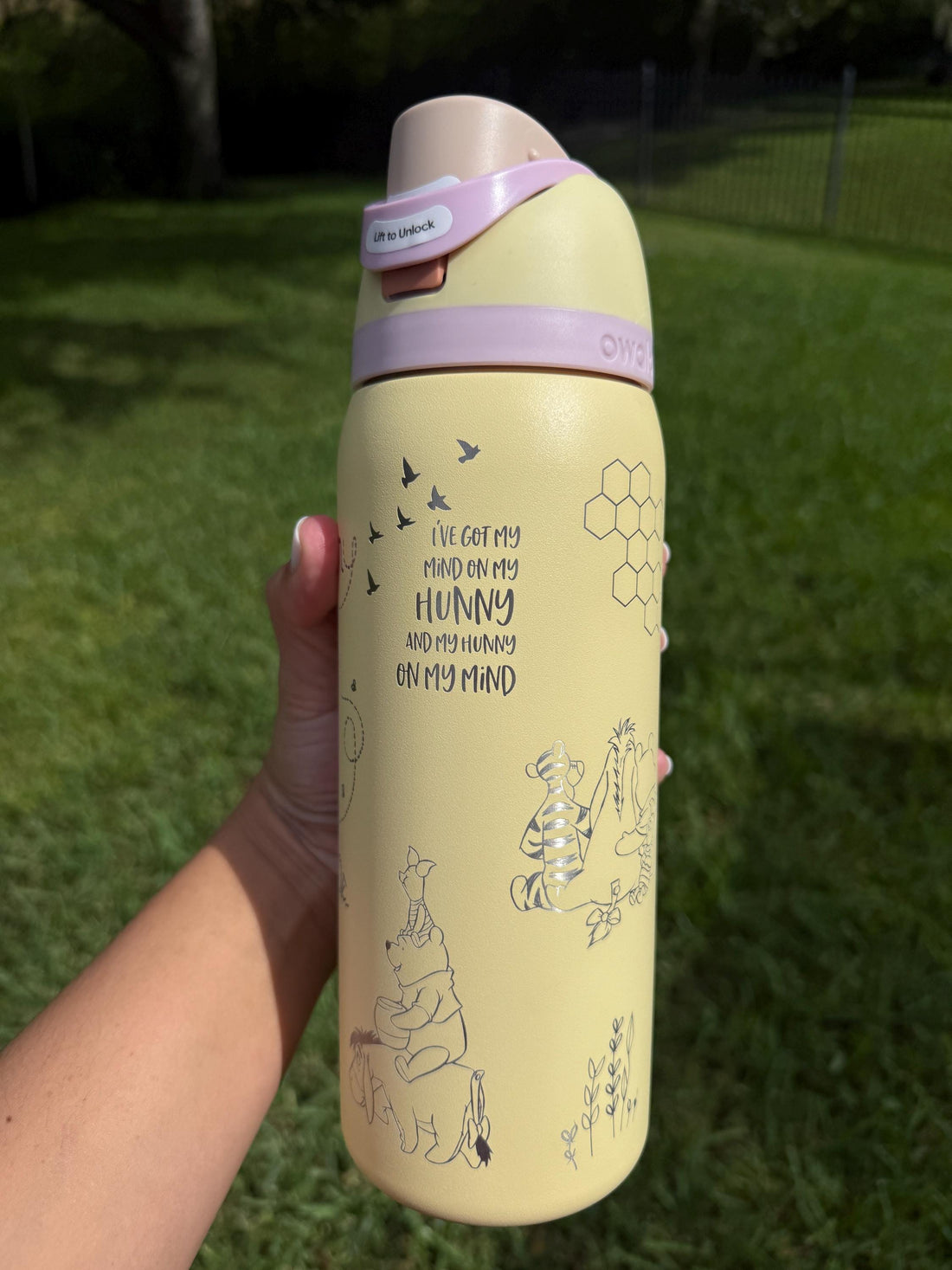 Yellow Owala FreeSip with lavender lid, laser engraved with a Winnie the Pooh-inspired design