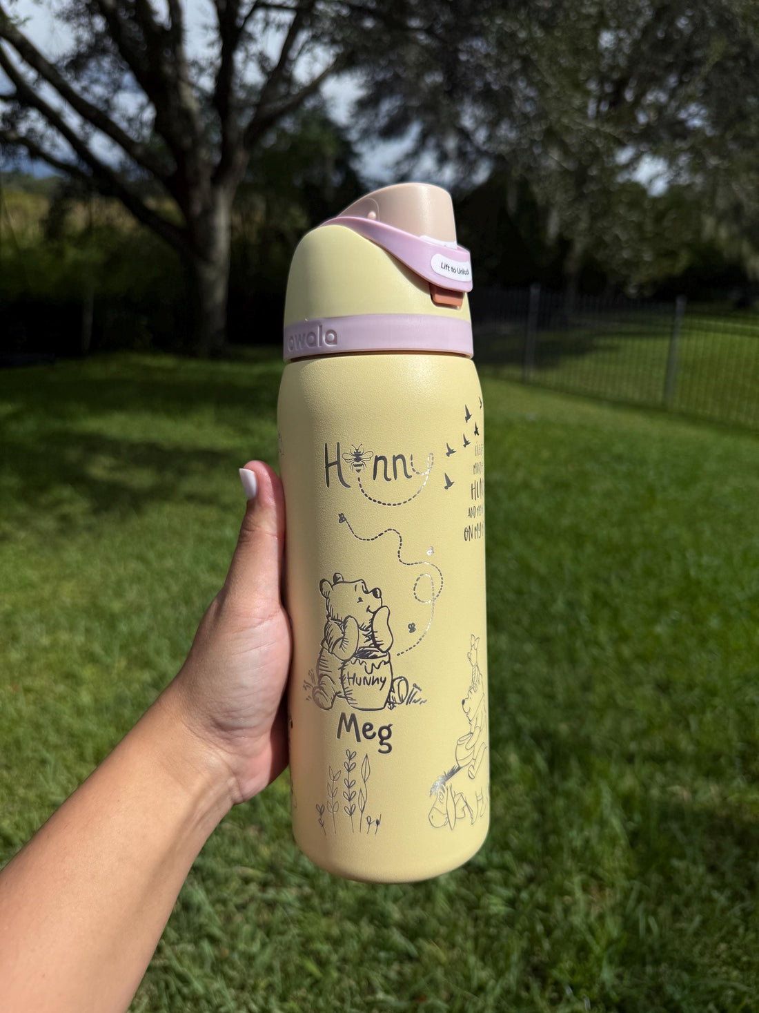Yellow Owala FreeSip with lavender lid, laser engraved with a Winnie the Pooh-inspired design