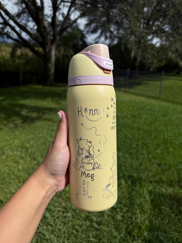 Yellow Owala FreeSip with lavender lid, laser engraved with a Winnie the Pooh-inspired design