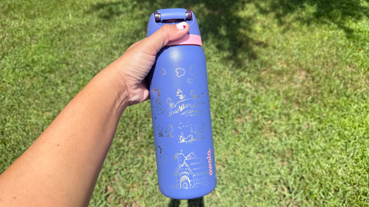 Side view of a periwinkle Owala FreeSip with Peanuts engraving