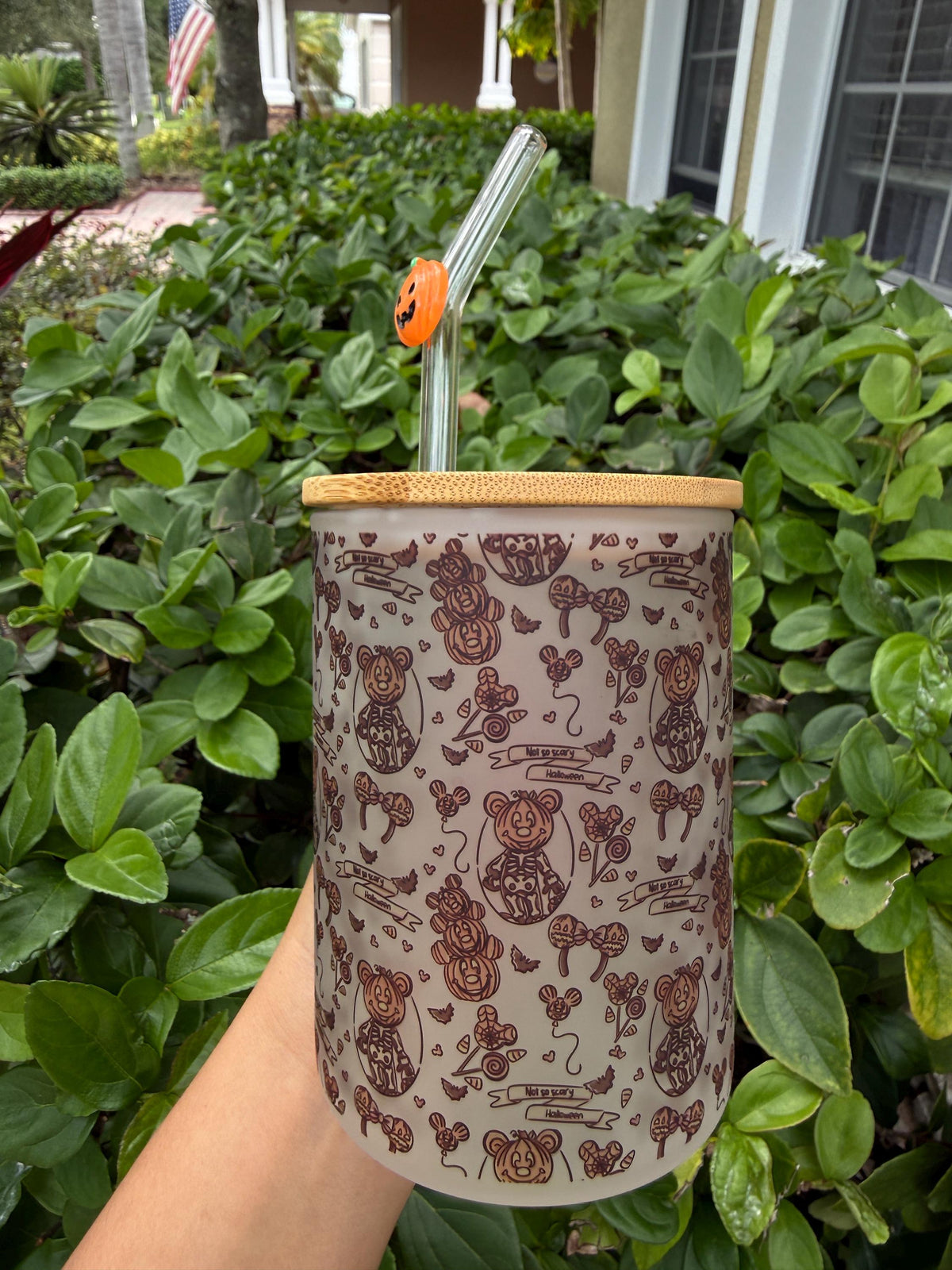 Side view of a frosted Halloween glass cup with floral skull print