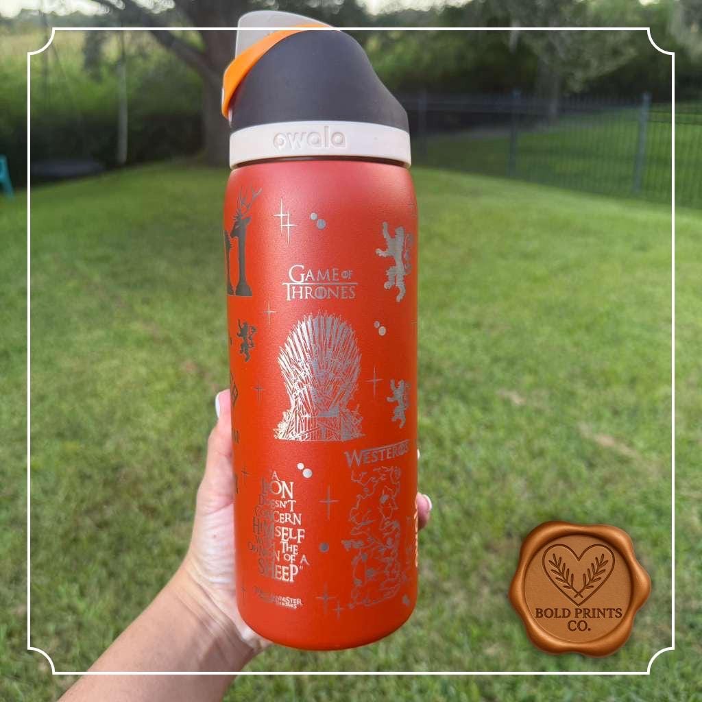 Back of an orange engraved Owala FreeSip held outdoors