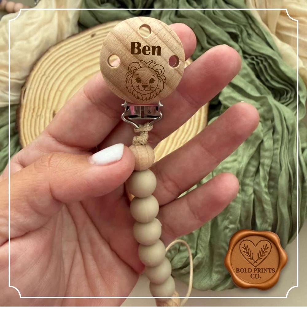 Close-up of a laser engraved name on a beechwood pacifier clip