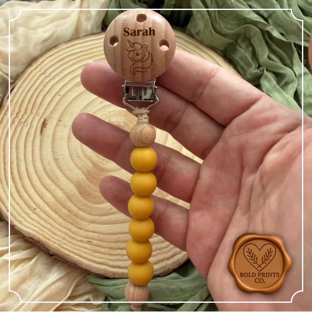 Mustard yellow silicone pacifier clip with engraved beechwood name