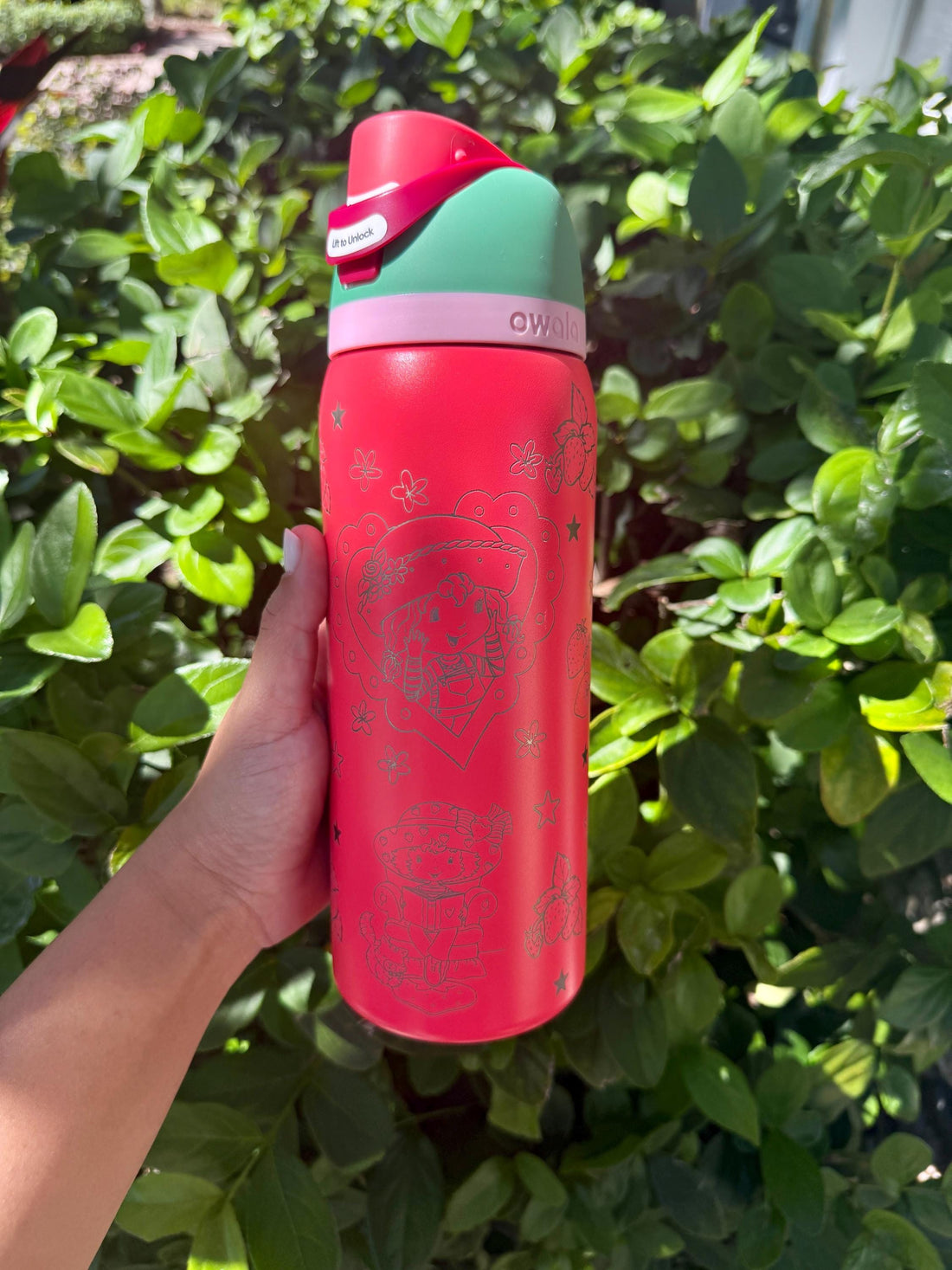 Pink Owala FreeSip with mint lid, laser engraved with a strawberry design