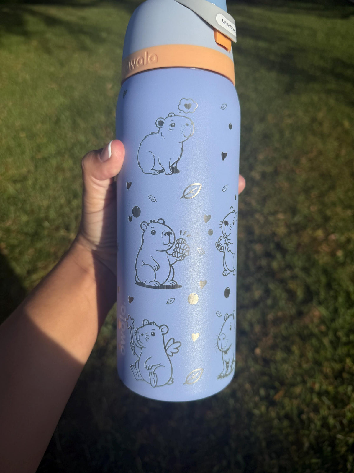 Back of a periwinkle Owala with more engraved capybaras