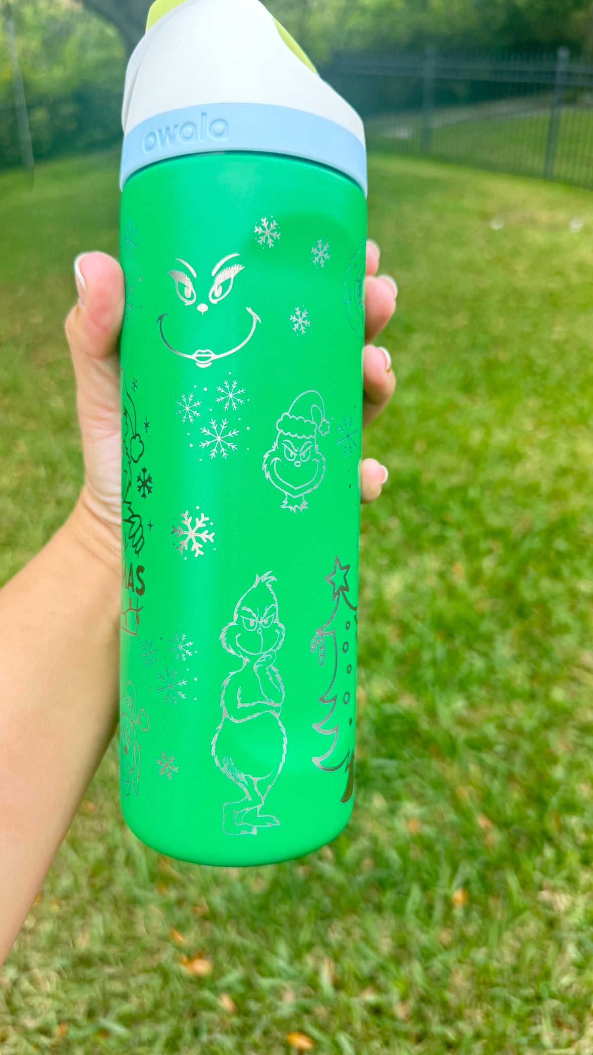 Close-up of Grinch-inspired face engraving on a green Owala