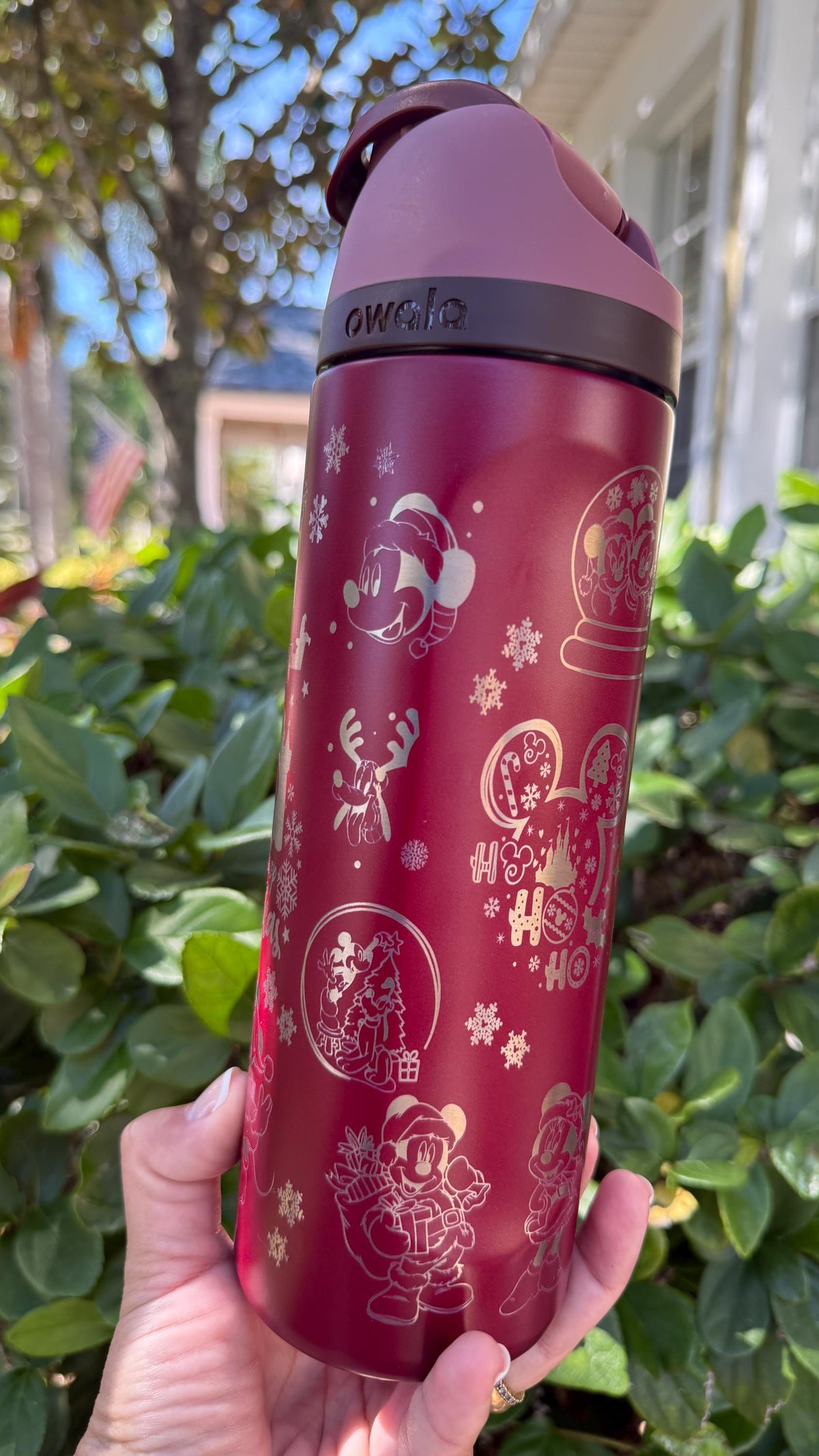 Side view of a red Owala with engraved snowflakes and holiday icons