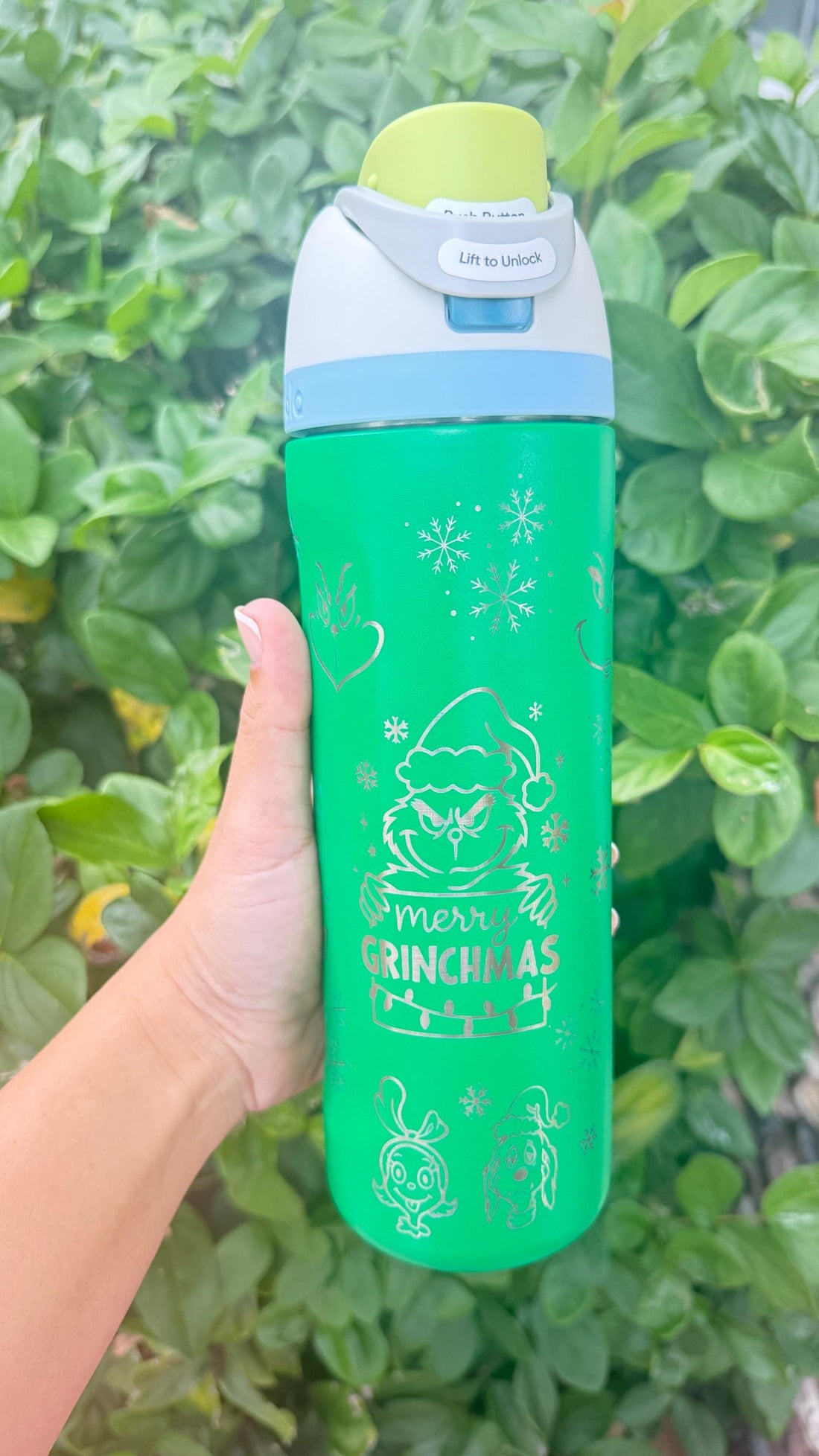 Bright green Owala FreeSip laser engraved with a Grinch-inspired Christmas design