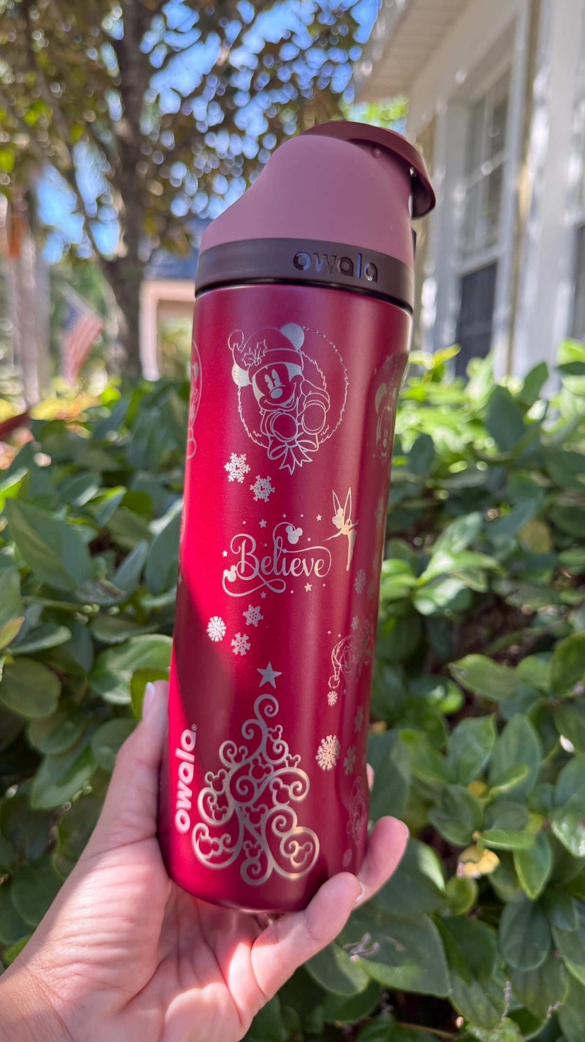 Red engraved Christmas Owala FreeSip held outdoors