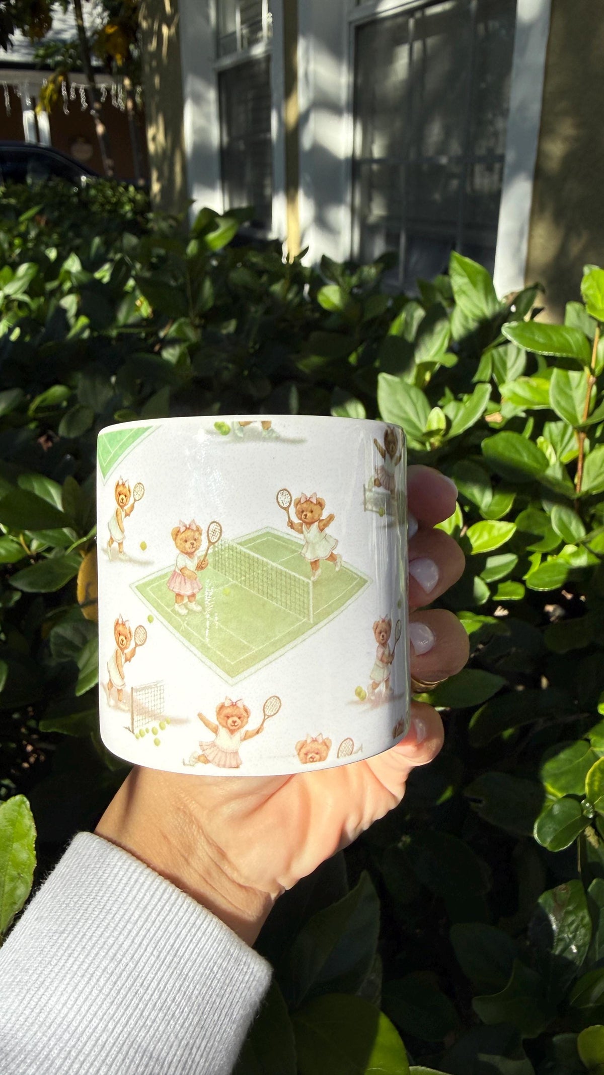 Enamel mug with tennis bears and a green court illustration