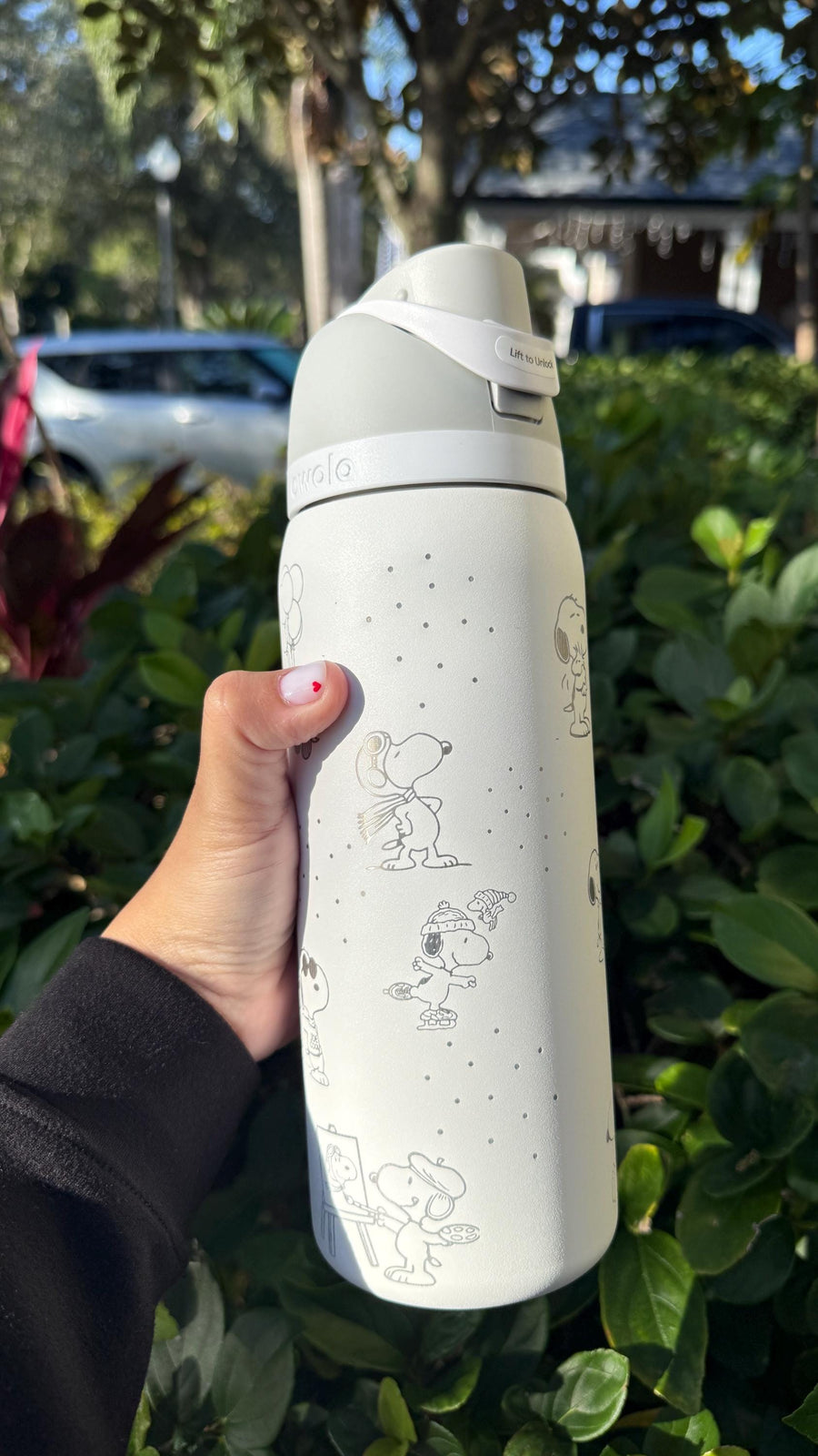 Side view of a cream Owala with engraved Snoopy and Woodstock