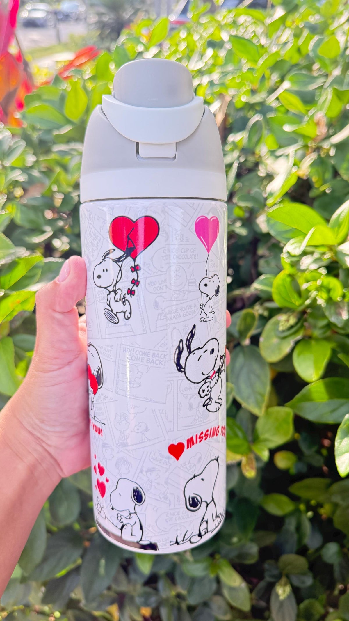 Side view of a white Snoopy Valentine's tumbler with red and pink hearts