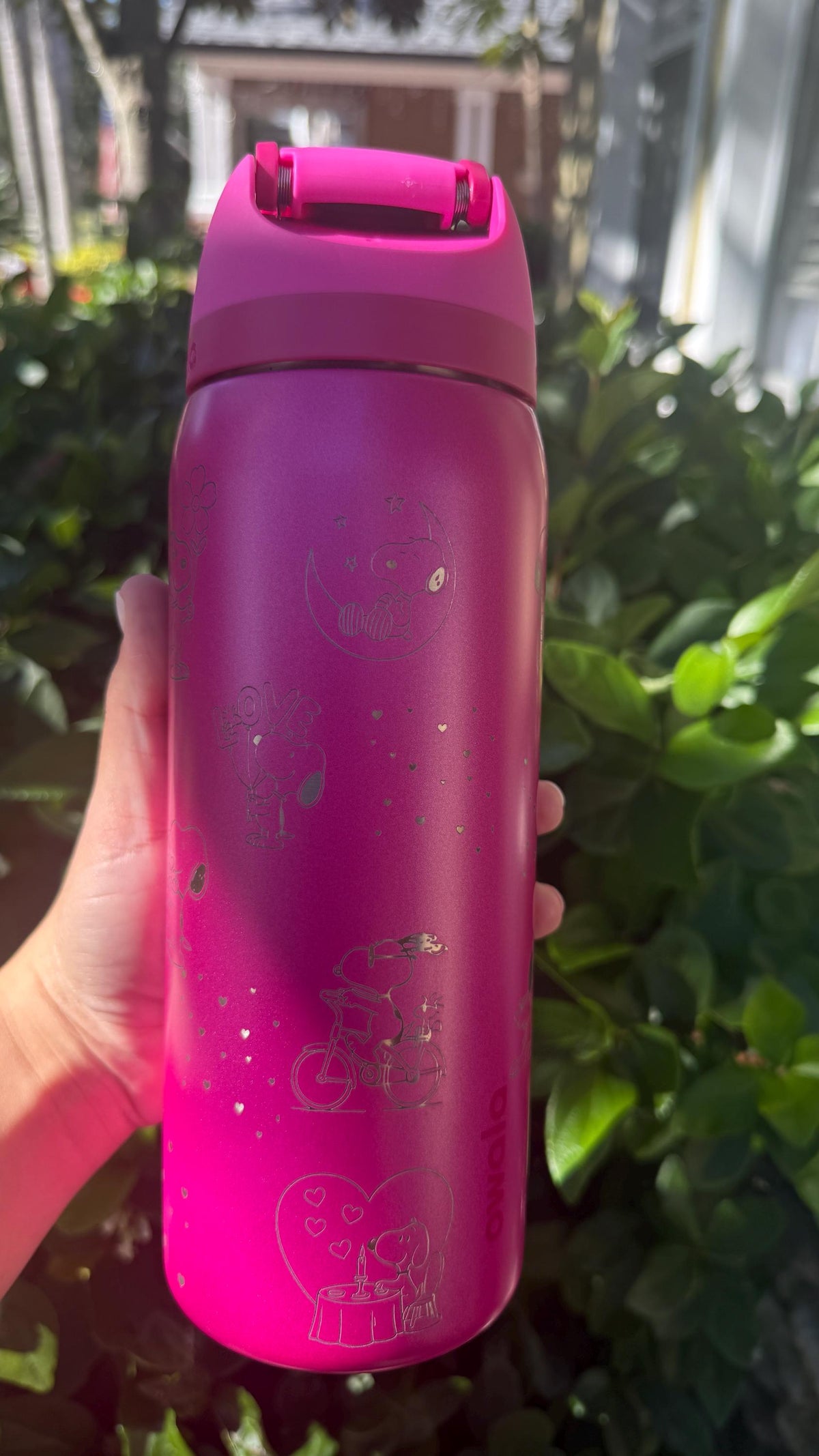 Back of a magenta Owala with engraved hearts and Snoopy
