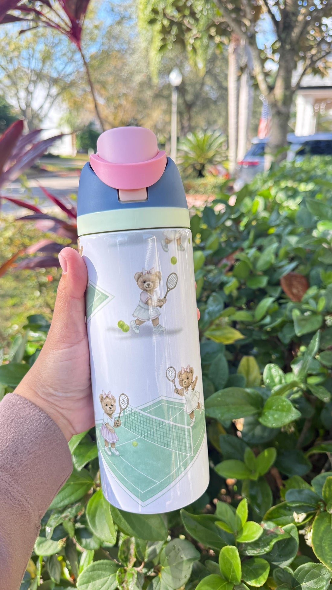 White FreeSip-style tumbler printed with a tennis bear and green court design, blue lid