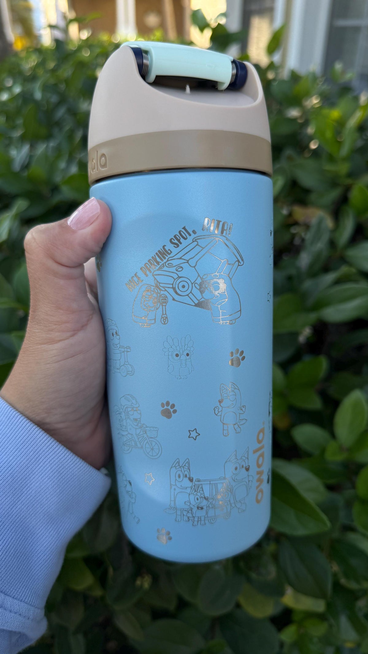 Close-up of engraved house and paw prints on a light blue Owala