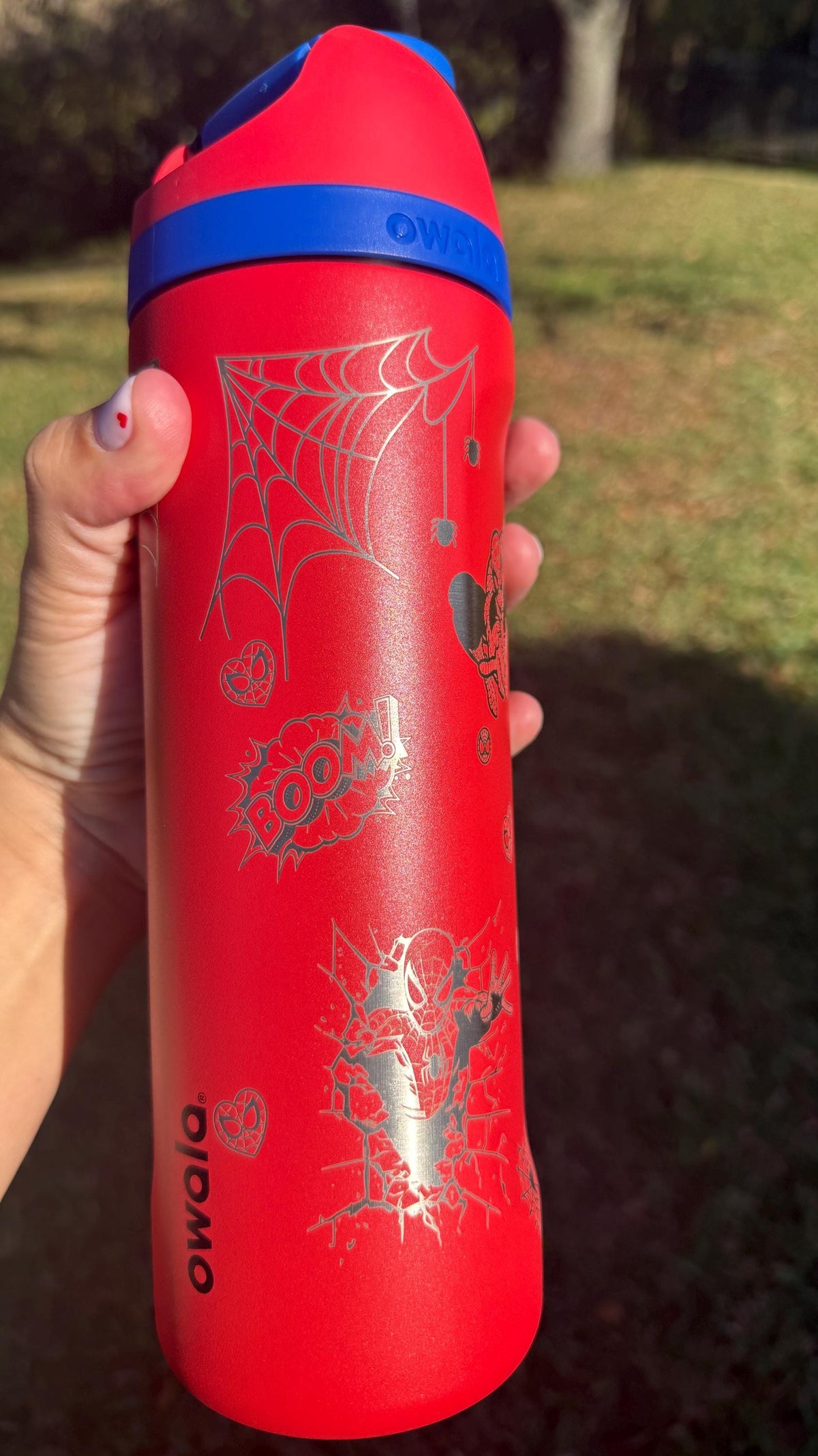 Side view of a red Owala with engraved spider webs