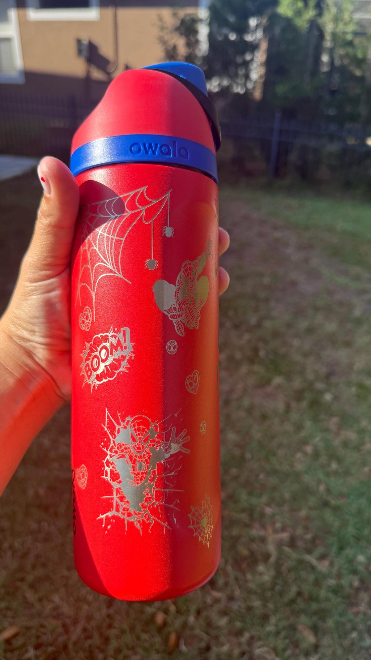 Close-up of Spider-Man engraving on a red Owala water bottle