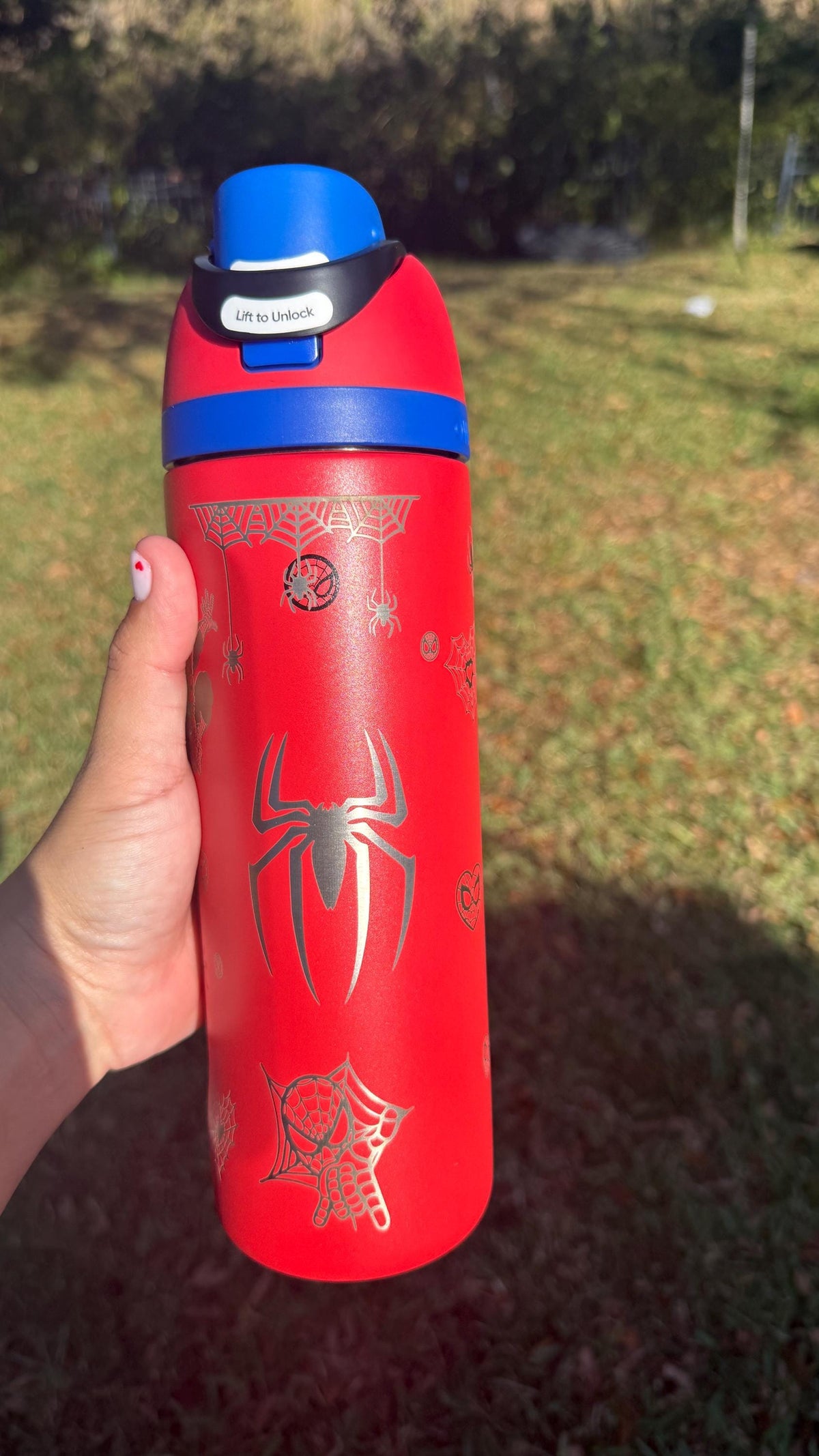 Spider logo engraved on a red Owala FreeSip with blue lid