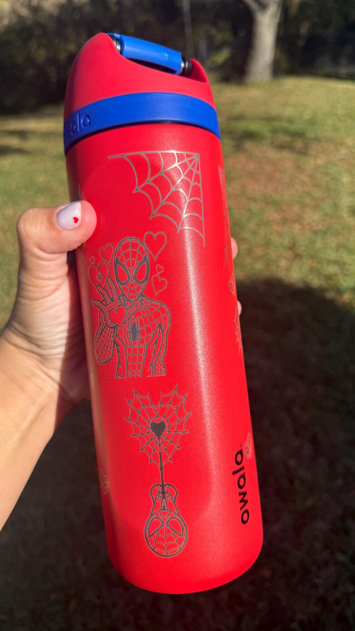 Red Owala FreeSip laser engraved with a Spider-Man design and spider webs
