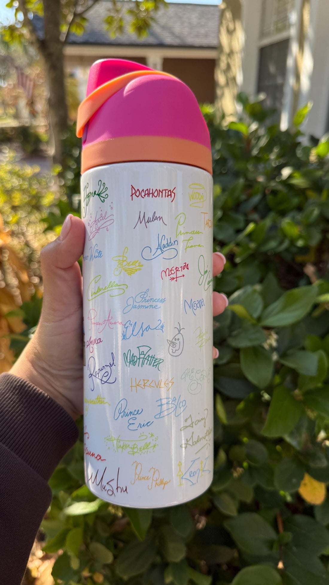 White FreeSip-style tumbler printed with colorful Disney-inspired character signatures and a castle