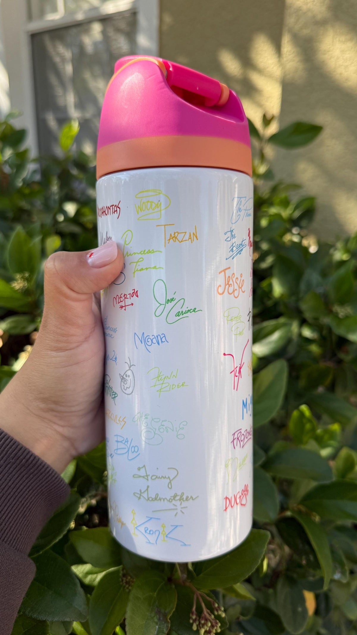 Printed character signatures tumbler held outdoors