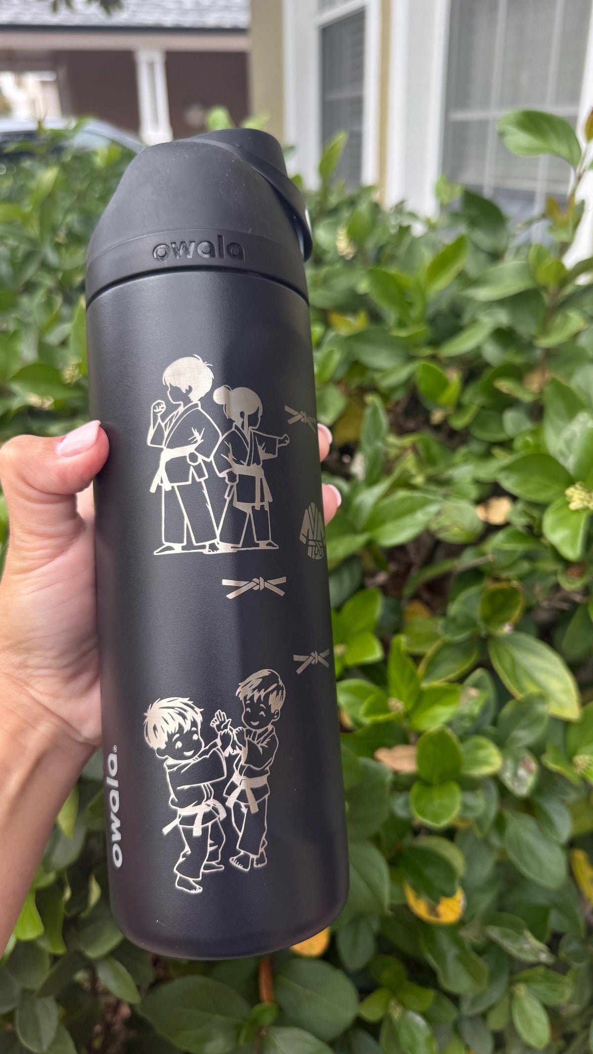 Engraved BJJ kids in gis on a black water bottle