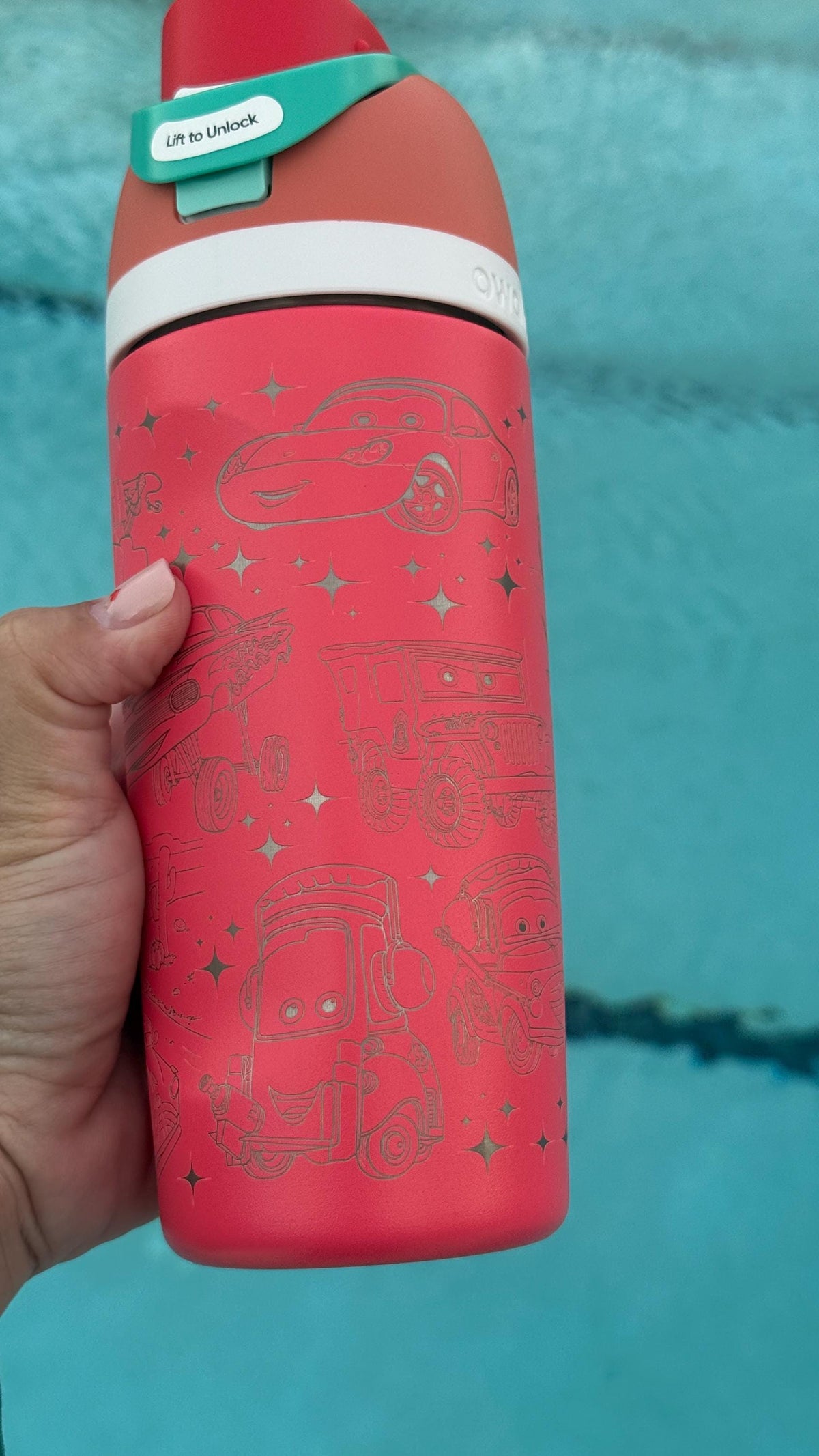 Side view of a red Owala bottle with engraved race car artwork