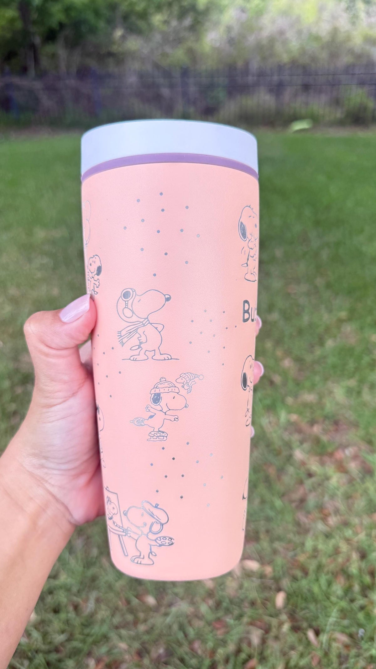 Pink Owala SmoothSip with a laser engraved Snoopy design, held outdoors