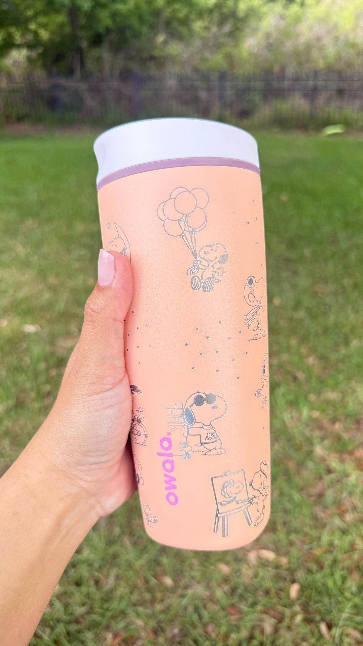 Side view of engraved Peanuts characters on a pink Owala SmoothSip tumbler