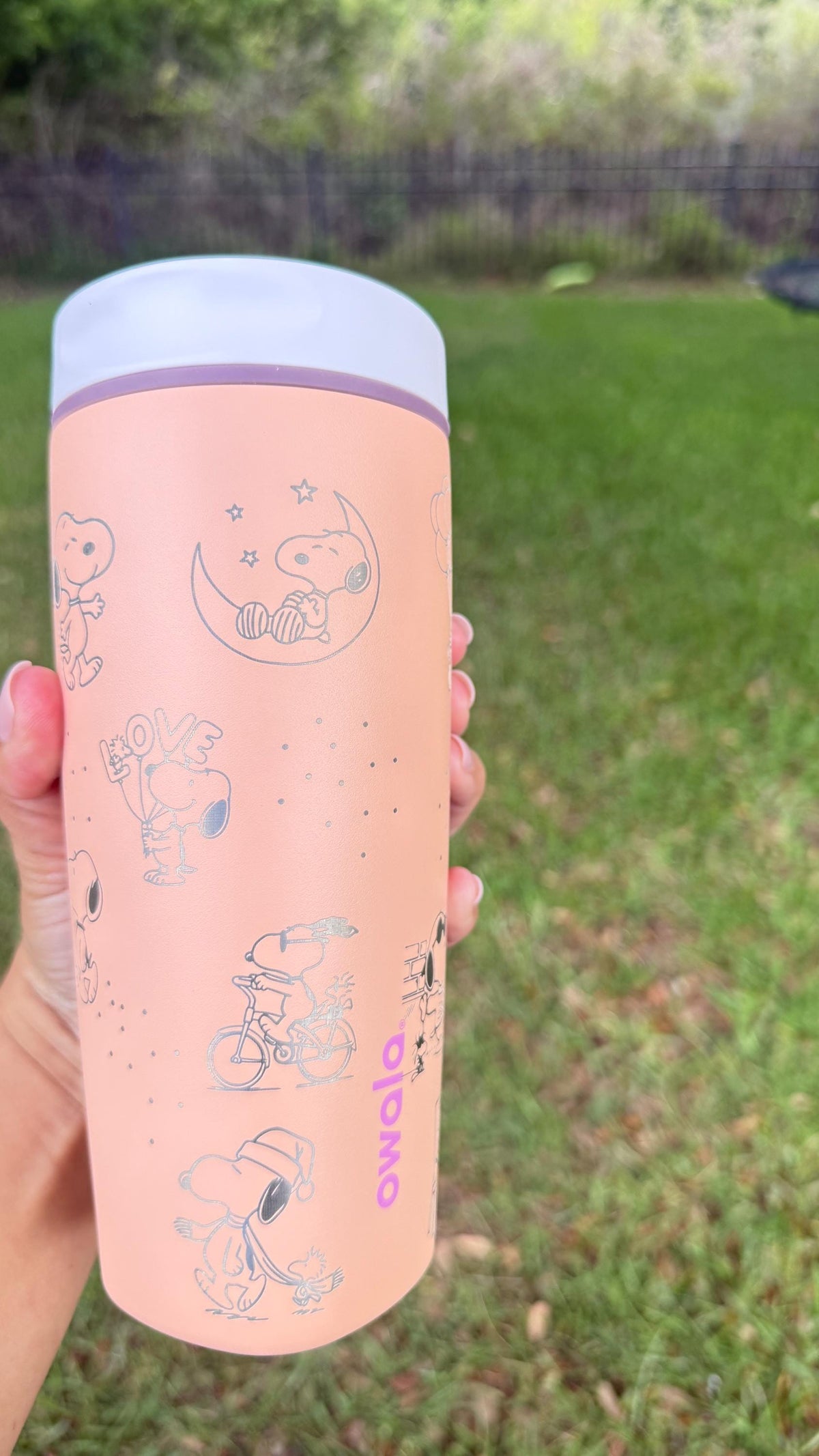 Close-up of Snoopy and Woodstock laser engraving on a pink Owala SmoothSip