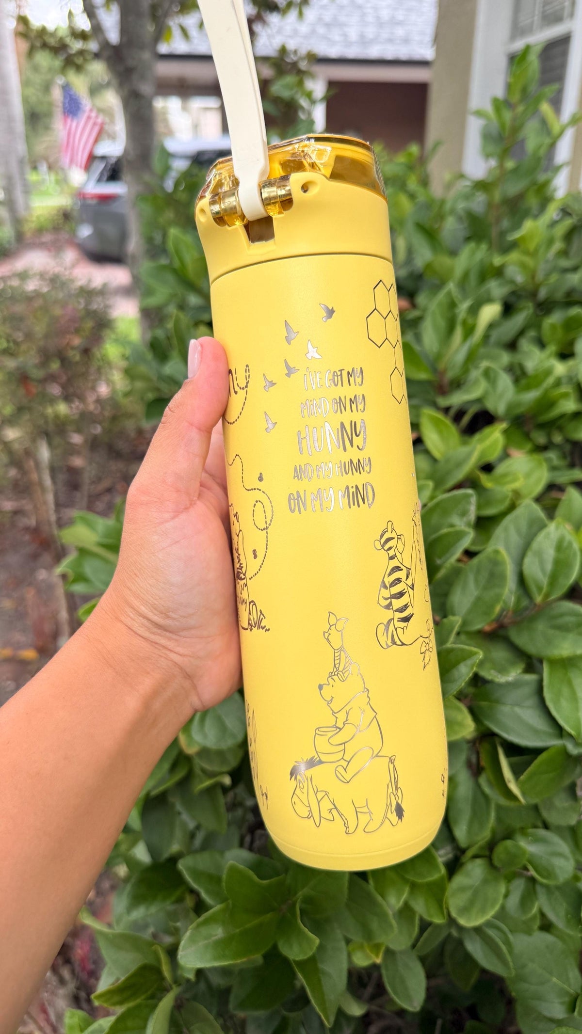 Side view of a yellow Stanley FlowState with engraved Pooh artwork