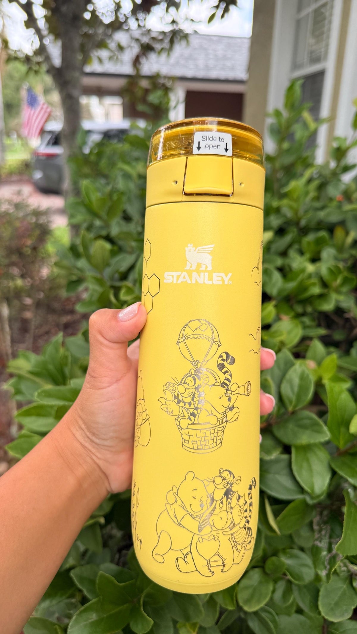 Close-up of the Stanley logo and Pooh engraving on a yellow tumbler