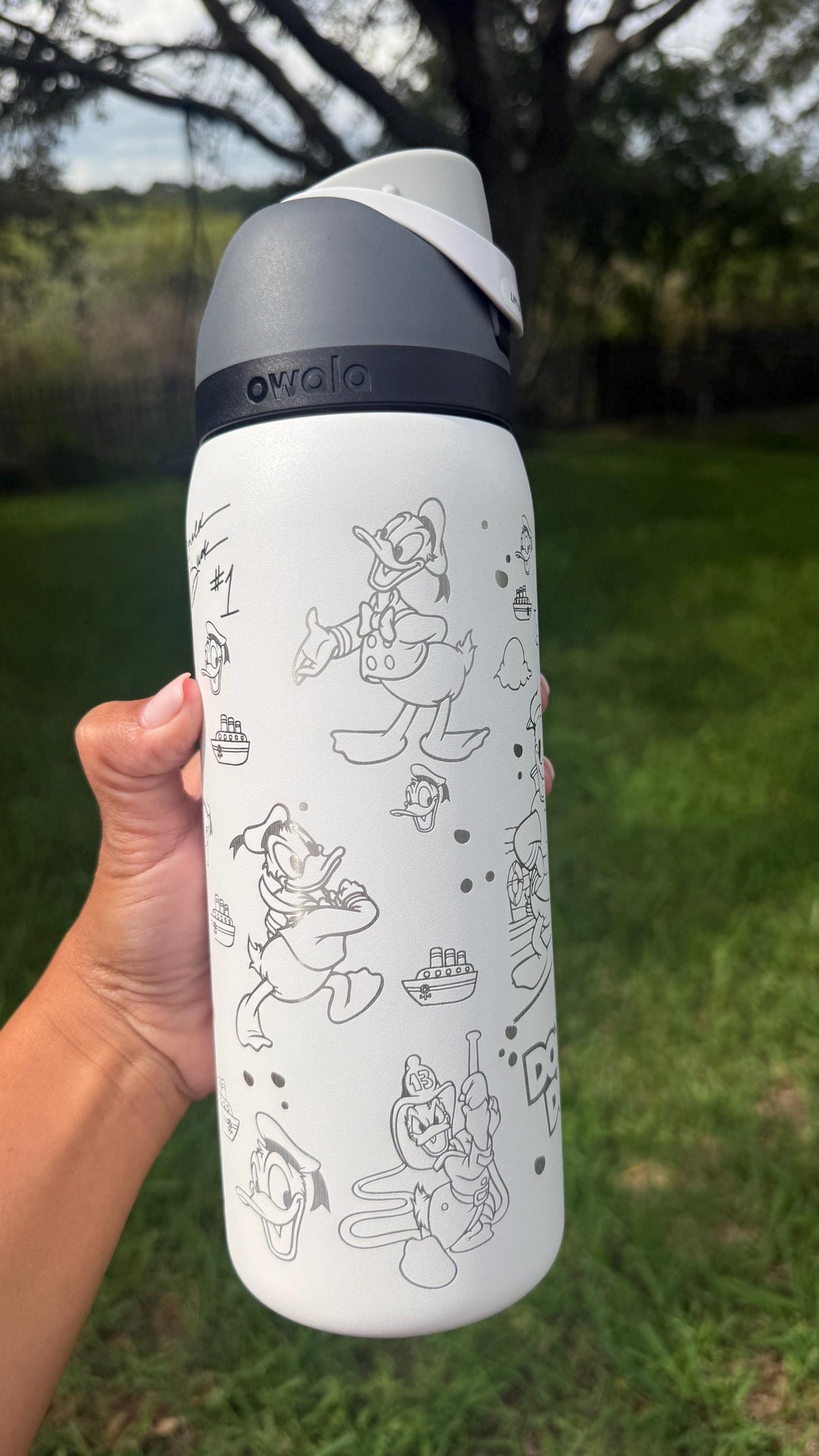 Close-up of Donald Duck engraving on a white Owala water bottle