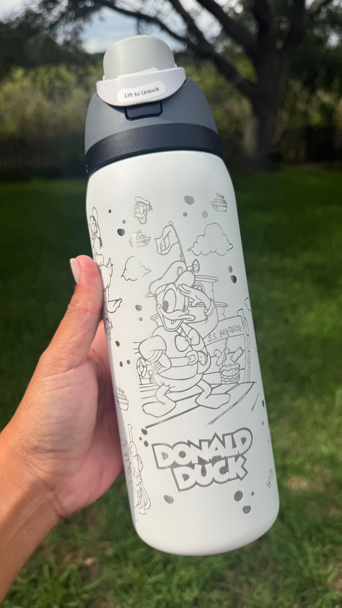 White Owala FreeSip engraved with Donald Duck artwork and a name