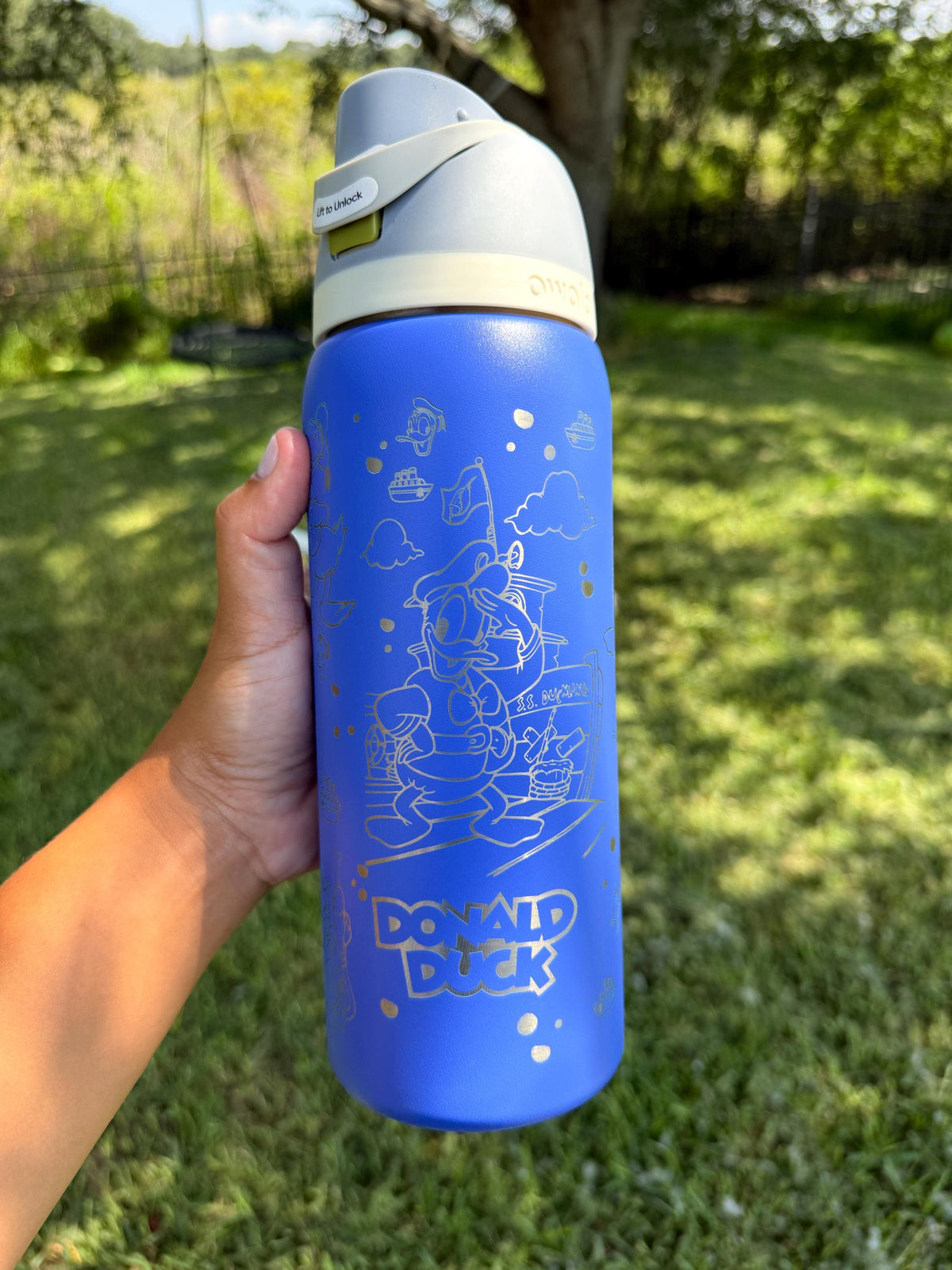 Blue Owala FreeSip laser engraved with a Donald Duck-inspired design