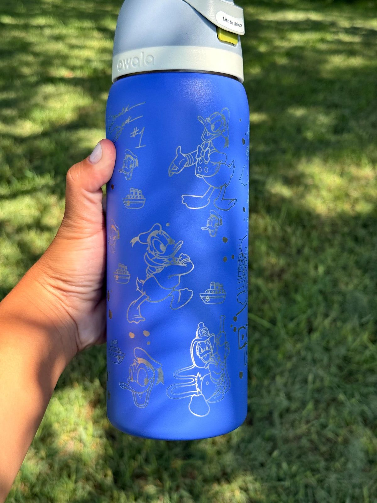 Close-up of the Donald Duck engraving on a blue Owala bottle