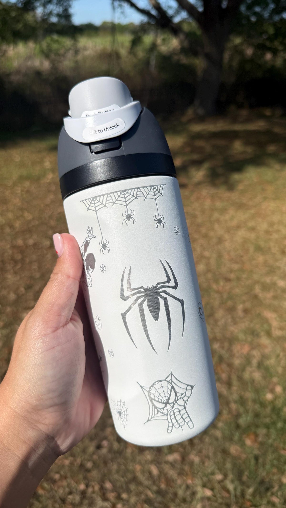 Spider logo engraved on a white Owala FreeSip