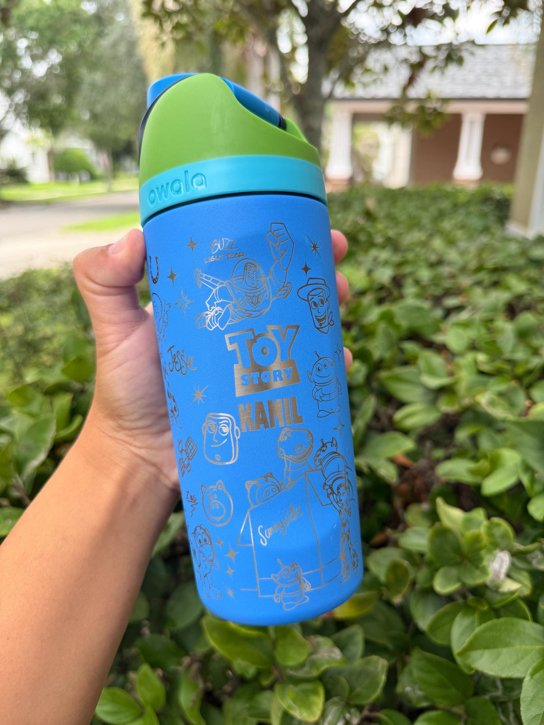 Blue Owala FreeSip with green lid, laser engraved with a Toy Story-inspired design