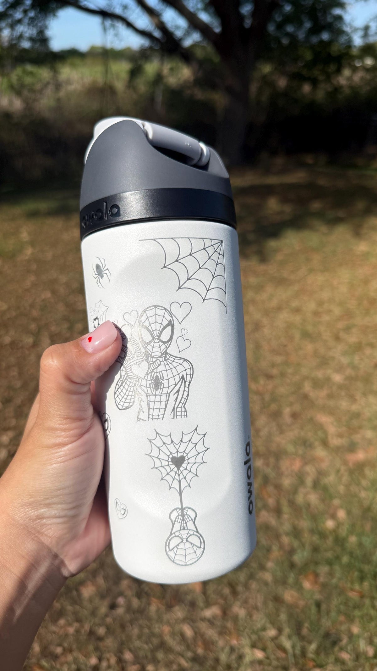 White Owala FreeSip laser engraved with Spider-Man and spider webs