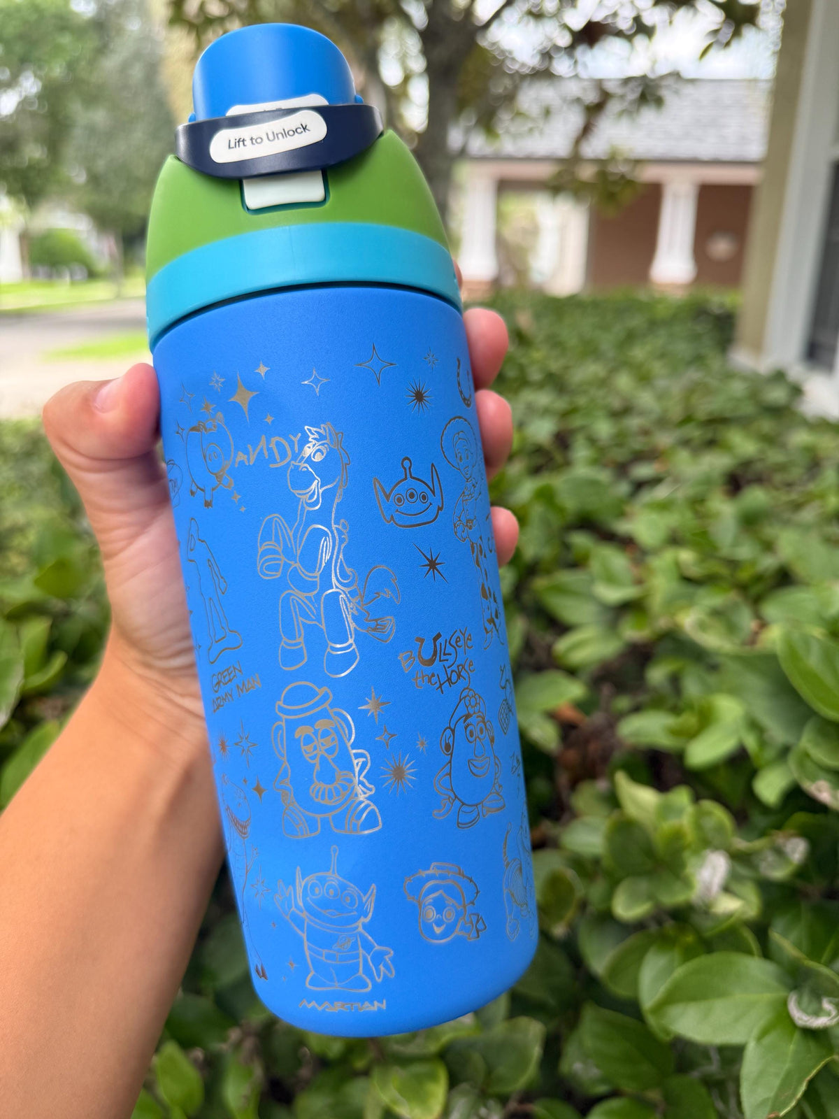 Blue engraved Owala FreeSip held outdoors